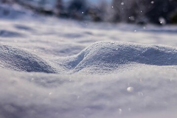 Close-up shot of beautiful white smooth snow in sunlight.