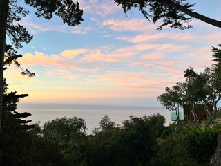 Stunning sunset over a picturesque landscape with trees in the foreground