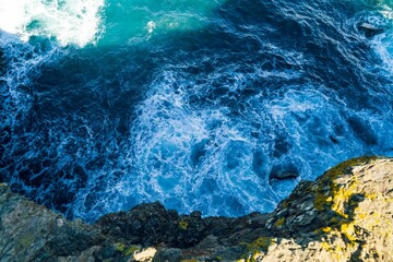 You get a bird's-eye view of the waves crashing on a mountain. It is a landscape shot