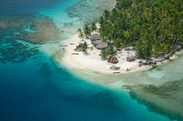 Aerial view of thatched houses and palm tree forest in island. San Blas archipelago, Caribbean, Panama, Central America.