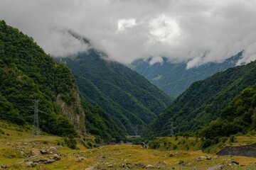 Obraz premium Peaceful scene of mountainous terrain featuring lush green grass and rocky outcrops in Georgia