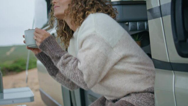 Relaxed traveller drinking coffee sitting trailer stairs close up. Happy woman