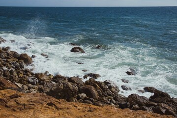 Fototapeta na wymiar Rocky cliff overlooking an expansive ocean.