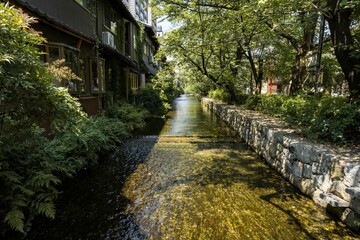 a river runs through a lush green area with stone walls