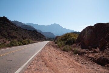 a road going through a scenic, arid area with mountains in the background