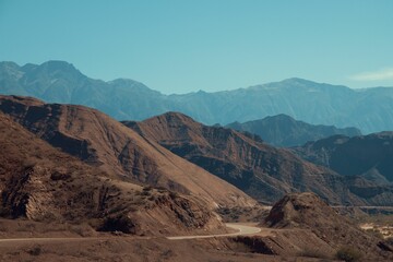 Picturesque desert mountain landscape featuring a meandering road winding through its terrain