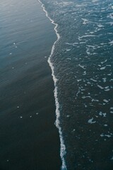 Close-up of beach shoreline, with the ocean waves splashing over the shore