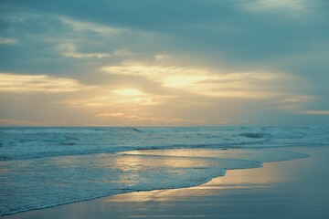 Beautiful sunset over the beach with the ocean waves gently crashing against the shore