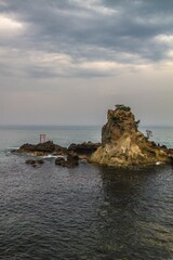 A shrine situated atop a beach surrounded by the sea