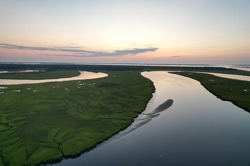 Aerial view of a river flowing through a green landscape at sunset