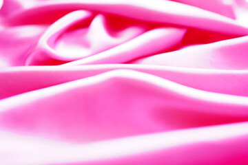 Pink silk or satin background, wavy, elegant and elegant. Close-up, background. Space for...