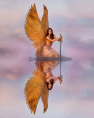 A golden angel kneeling on a pink lake