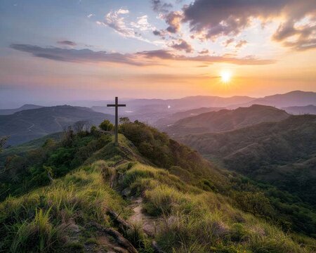 A Christian cross on a verdant hill is illuminated by the gentle rays of dawn's first light.