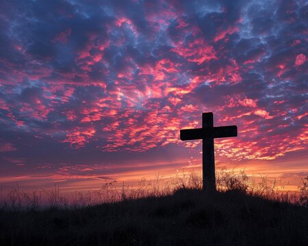 Under the dawn's first light, a Christian cross graces the verdant hillside.