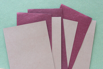 layered textured blank paper cards in burgundy and brown on green