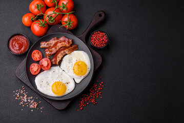 English breakfast with fried eggs, bacon, beans, tomatoes, spices and herbs