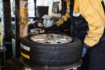 Expert Mechanic Inspecting Vehicle Tire and Rim - 771577789