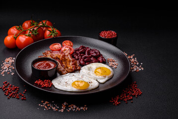 English breakfast with fried eggs, bacon, beans, tomatoes, spices and herbs