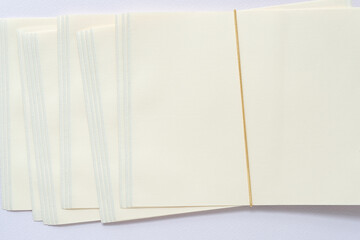 rear of a packet of stationery paper and tie string on toned, textured paper