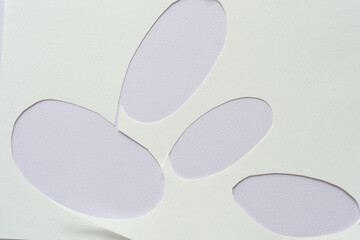 blank paper with oval cutouts placed on paper with texture
