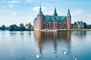  View of Frederiksborg castle with white swans on lake in Hillerod, Denmark © Elena Noeva