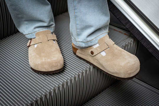 Close-up of man's feet in beige Birkenstock Boston on escalator on March 16, 2024, in Bangkok, Thailand.