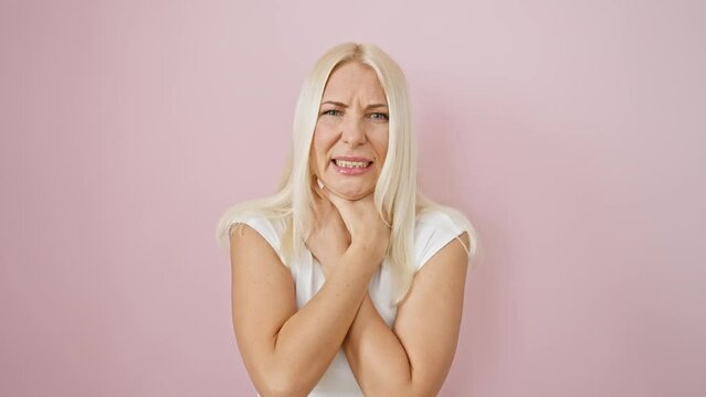 Distraught blonde woman struggling to breathe, strangle-induced pain and asphyxiation over pink isolated background