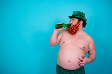 A funny fat man in a leprechaun costume drinks green beer on St. Patrick's Day.