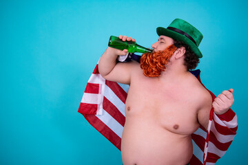A funny fat man in a leprechaun costume drinks green beer on St. Patrick's Day.