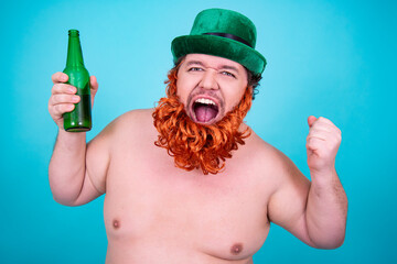 A funny fat man in a leprechaun costume drinks green beer on St. Patrick's Day.