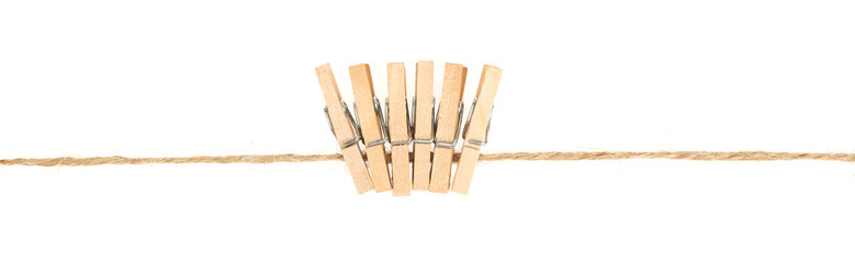 wooden clothespins on clothesline isolated white background. household сlothes pins on a jute rope - obrazy, fototapety, plakaty