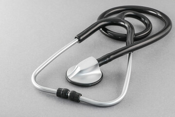 Black stethoscope on a gray background