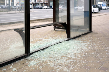 A lot of broken glass at a public transport stop. An act of vandalism.