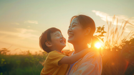 Asian mother and son smiling at sunset, woman holding child in her arms, nature background, warm colors