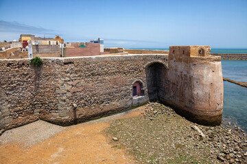 View of the defending walls of Portuguese build fortified port city Mazagan, currently El Jadida, UNESCO heritage. Long stone walls surrounding the city and bordering the sea. Morocco, Africa.