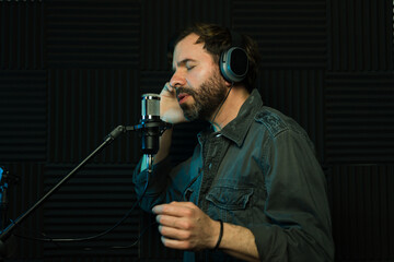 Profile view of a male vocalist recording in studio