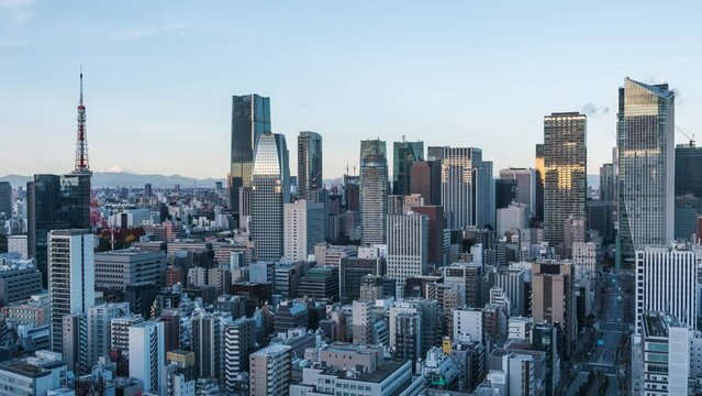 Timelapse view of sunrise over skyscrapers in the Minato district of Tokyo, Japan, zoom out. 