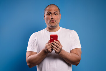 man holding a cell phone and surprised