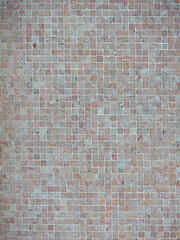 One wall with littles mosaic tiles from different colors beige ocre to white blue - soft colors. Textured square tile full frame photography