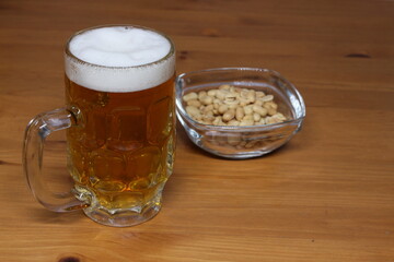 Image of a glass of beer and a plate of nuts.