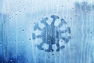 coronavirus molecule figure is painted on wet blue window with raindrops concept photo...