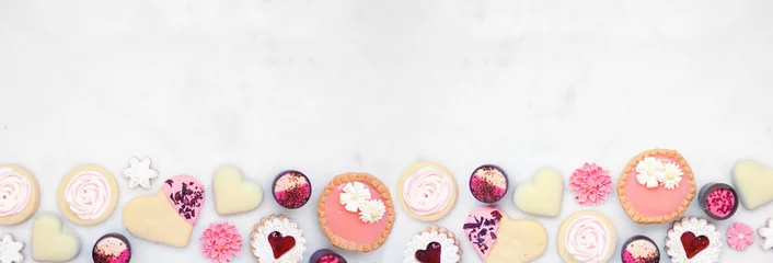 Foto op Canvas Mothers Day or love themed baking bottom border with a selection of cookies and sweet treats. Top down view on a white marble banner background with copy space. © Jenifoto