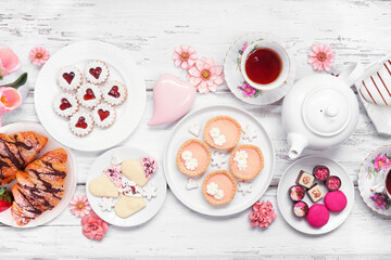 Mother's Day tea table scene over a white wood background. Variety of sweet desserts and pastries. - 771655107