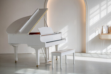 Large white grand piano in a sunny interior