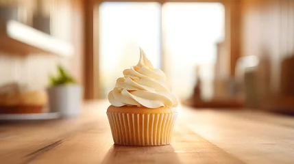 Foto op Canvas Close up of a ivory Cupcake on a wooden Table. Blurred Kitchen Interior Background © drdigitaldesign