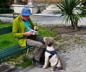 Mann und sein Lagotto Romagnolo Hund teilen sich eine Mahlzeit