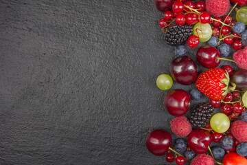 Various summer Fresh berries in a bowl on rustic wooden table. Antioxidants, detox diet, organic fruits. Top view