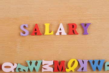 SALARY word on wooden background composed from colorful abc alphabet block wooden letters, copy...