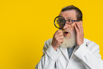 Investigator researcher scientist senior doctor cardiologist man holding magnifying glass near face...