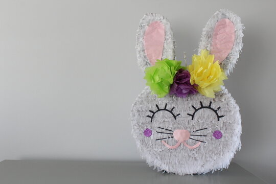 Piñata de conejo de pascua, elaborada con papel de colores. 